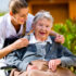 Senior woman in nursing home with nurse in garden